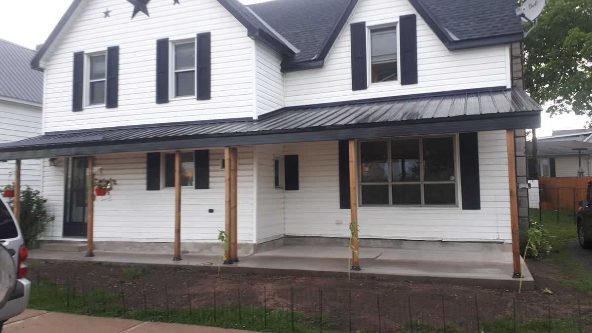 Porch with new concrete slab and metal roof after replacement